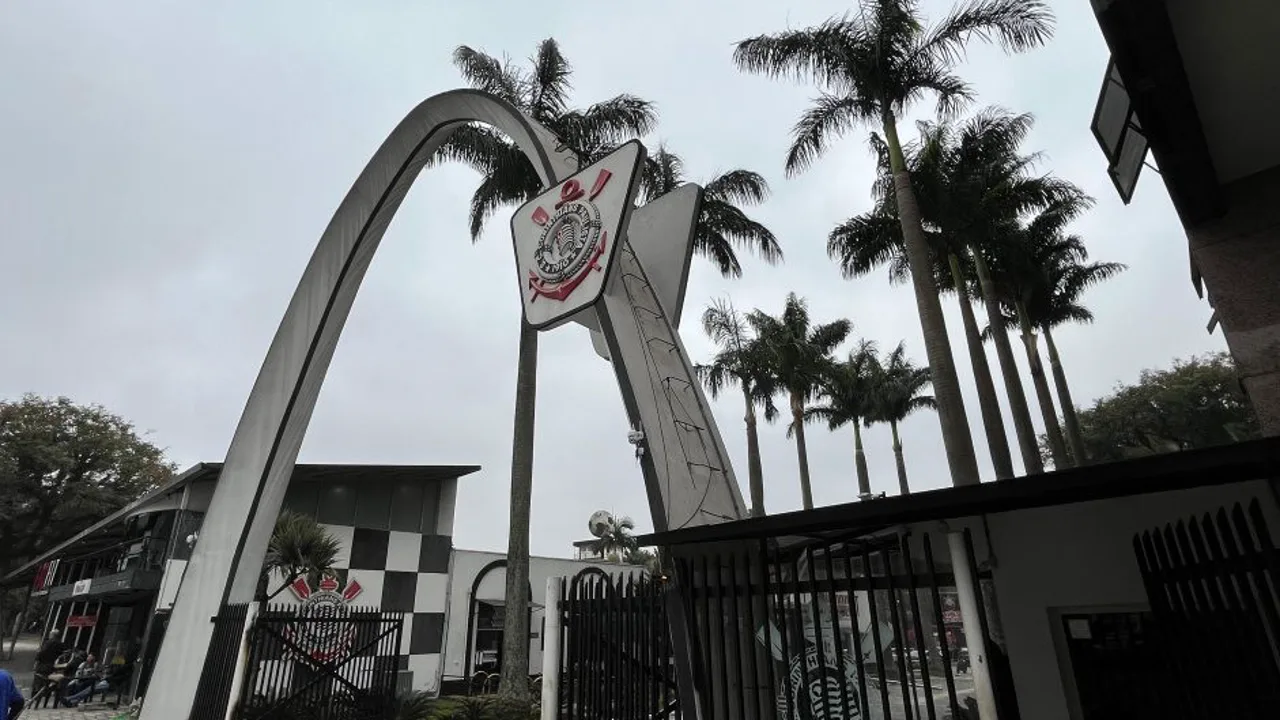 Fachada do Parque São Jorge, sede do Corinthians, com documentos e planilhas financeiras em primeiro plano