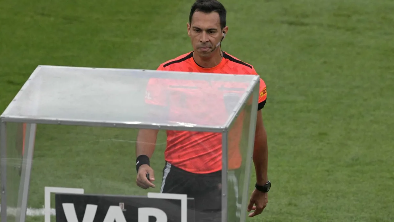 Árbitro gesticulando retângulo com os dedos sinalizando revisão de VAR durante partida de futebol