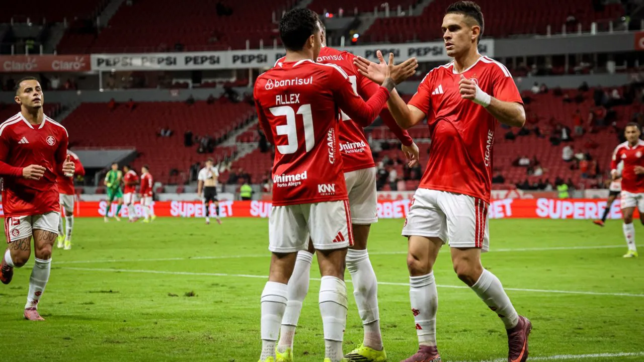 Analista esportivo com câmera próximo a campo de treinamento cercado, representando escândalo de espionagem na Championship inglesa