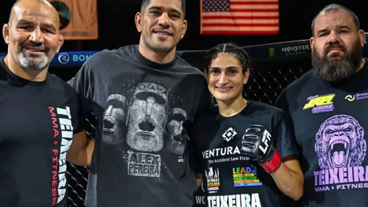 Aline Pereira em posição de luta no cage, com luvas de MMA, olhando para a câmera
