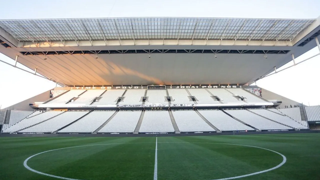 Fachada da Neo Química Arena em Itaquera com torcida do Corinthians ao fundo durante jogo noturno