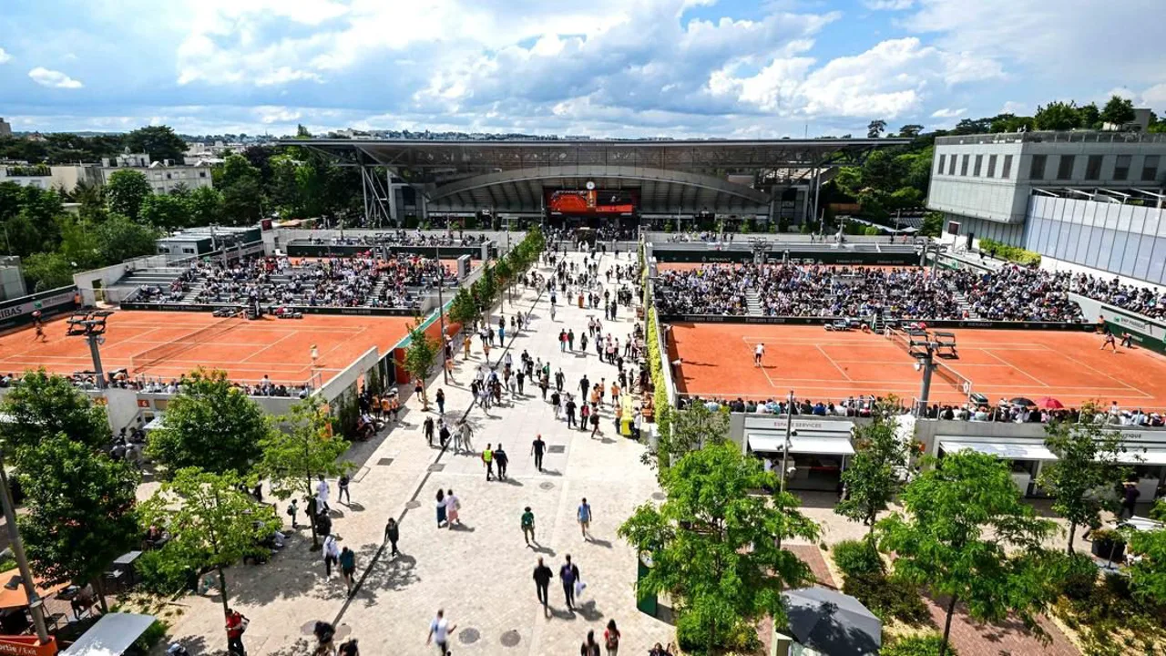 Tenista em quadra de saibro vermelho em Roland Garros durante partida das qualificatórias