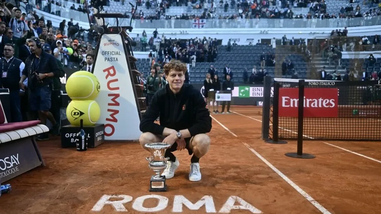 Jannik Sinner ergue troféu em quadra de saibro com punho cerrado, Roland Garros em segundo plano