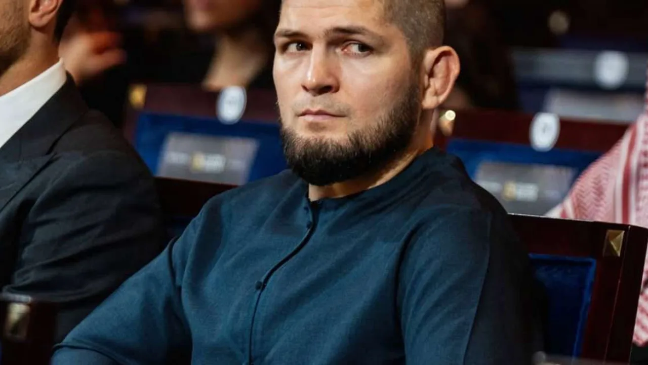 Khabib Nurmagomedov no octógono após vitória no UFC 254, olhando para cima com o cinturão dos leves