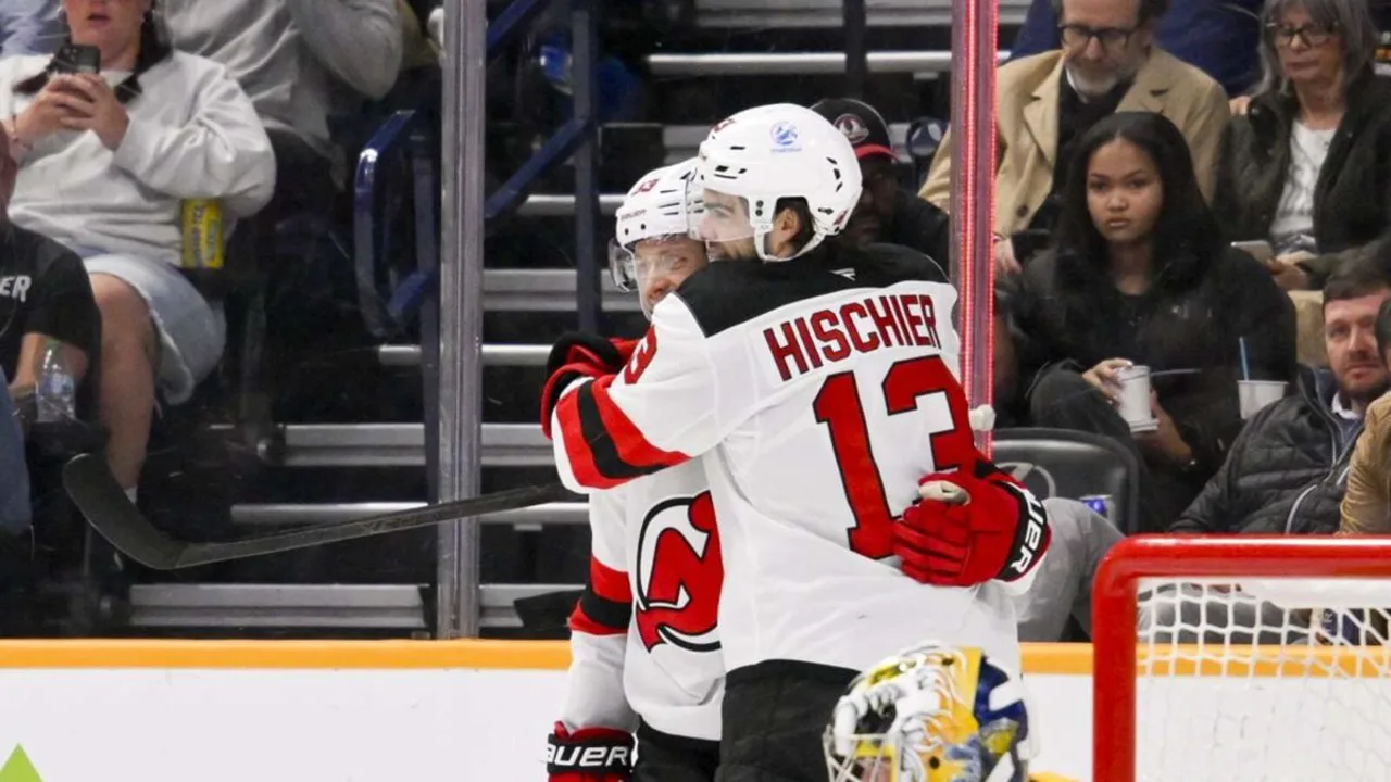 Nico Hischier com a camisa do New Jersey Devils durante partida da NHL, expressão concentrada no gelo