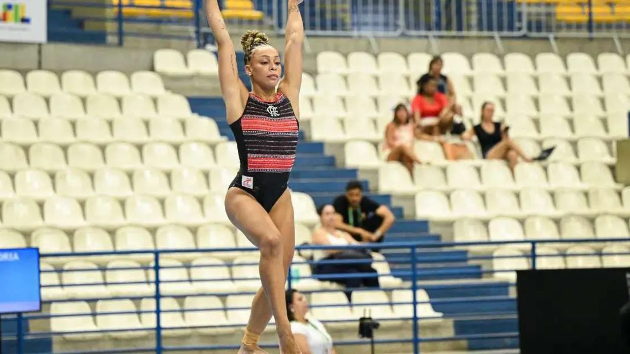 Ginasta feminina executando elemento na trave de equilíbrio durante competição internacional de ginástica artística
