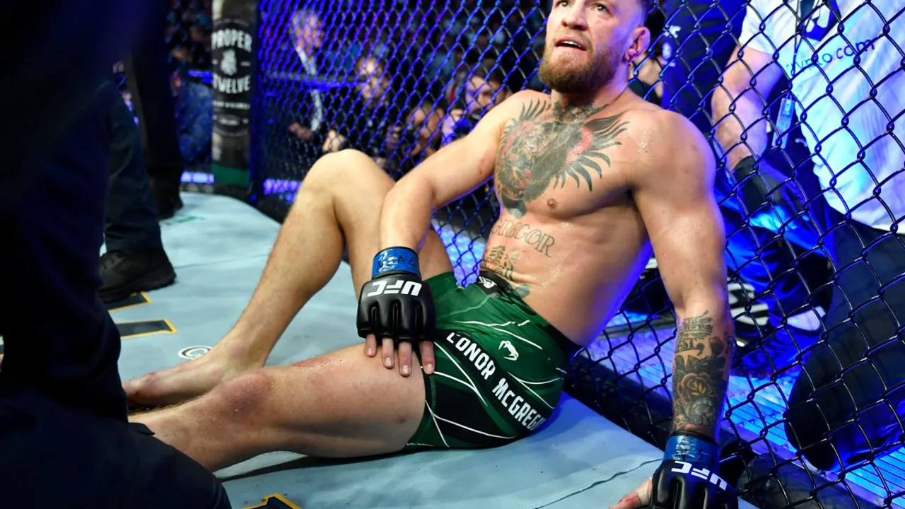 Conor McGregor sentado no octógono após fratura na perna no UFC 264 contra Dustin Poirier em Las Vegas