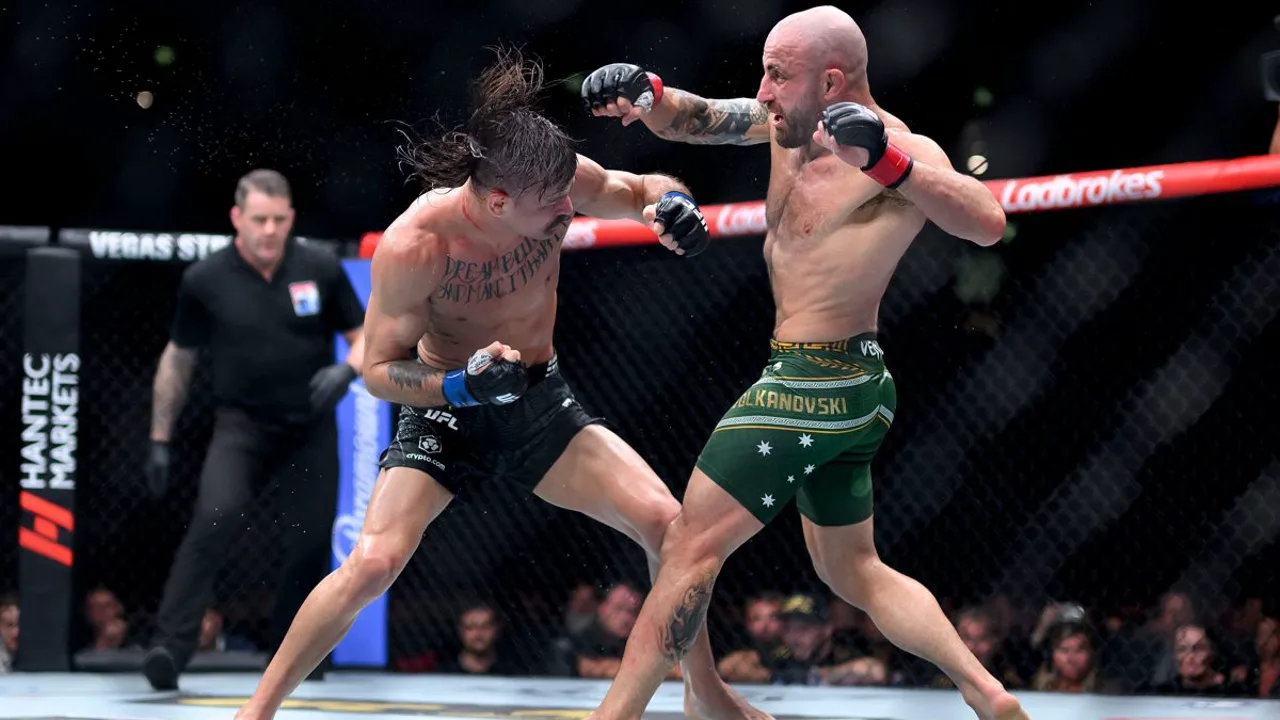 Diego Lopes e Alexander Volkanovski se encaram dentro do octógono do UFC, luvas erguidas, sob iluminação intensa do evento