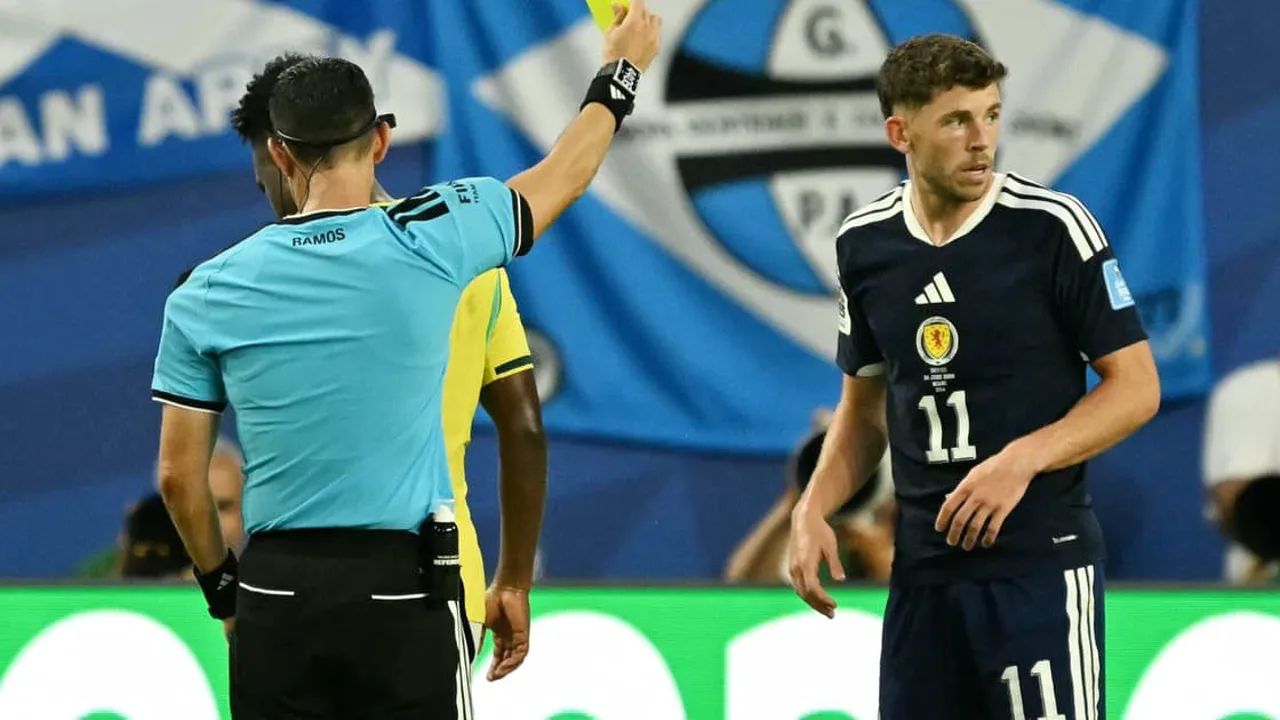 Árbitro exibindo cartão amarelo em partida da Copa do Mundo 2026 com jogadores ao redor