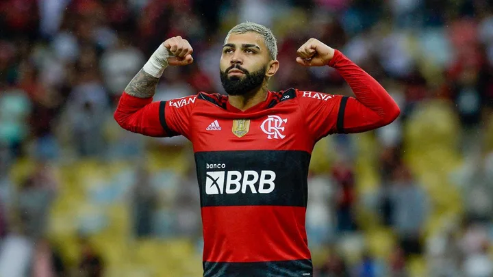 Árbitro de futebol consultando monitor de revisão VAR à beira do campo durante partida profissional