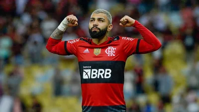 Árbitro de futebol consultando monitor de revisão VAR à beira do campo durante partida profissional